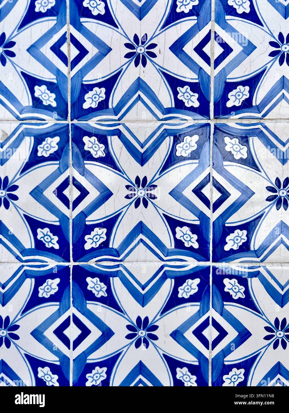 Carreaux azulejo bleus et blancs avec un motif floral géométrique répétitif sur un mur au Portugal - Image de stock capturée avec un smartphone