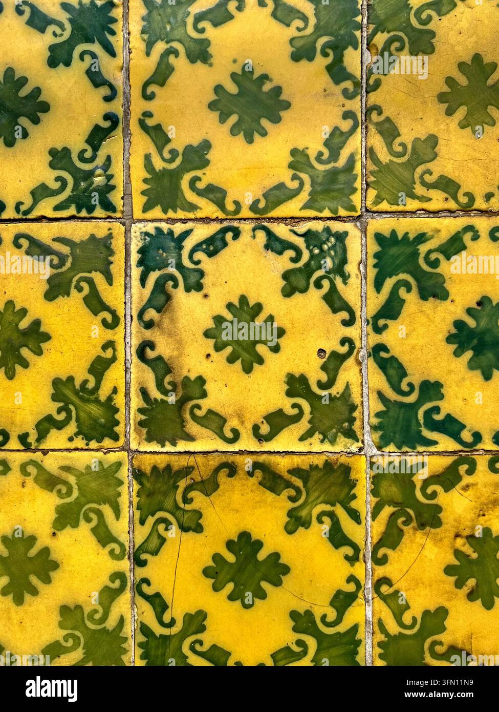 Anciennes tuiles en céramique azulejo jaunes et vertes peintes à la main avec un motif de feuille et de volute, Portugal - Image de stock capturée avec un smartphone