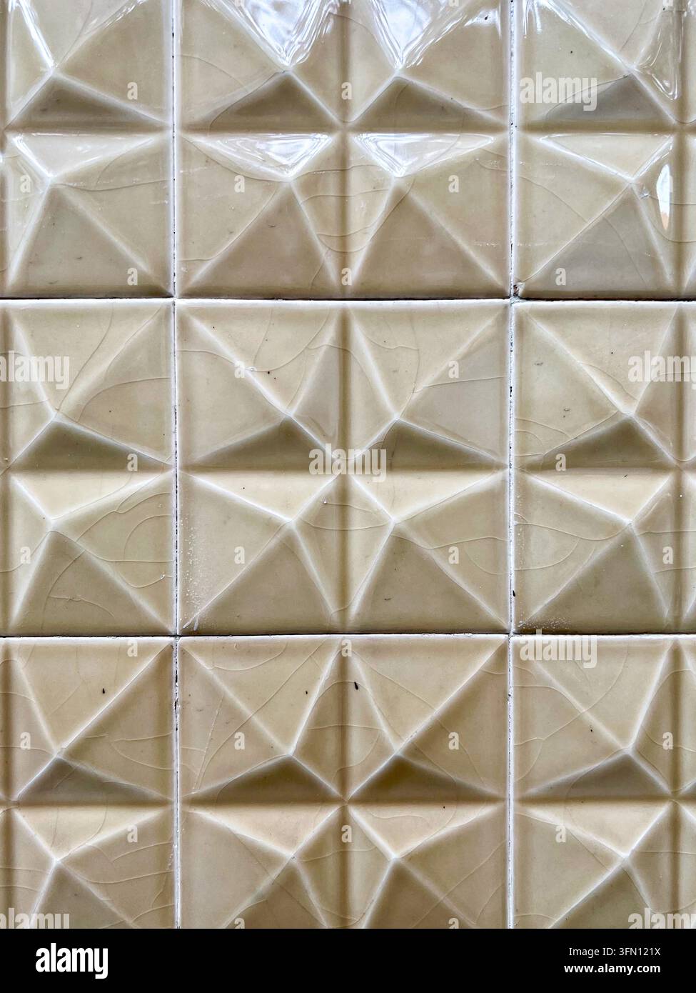 Carreaux azulejo beige brillants avec un relief géométrique en forme d'étoile en relief et une glaze craquelée sur un mur au Portugal Banque D'Images