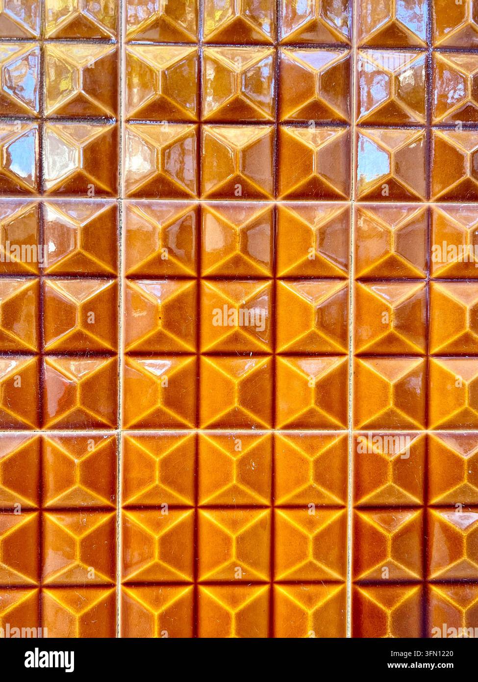 Carreaux de céramique azulejo orange brillant avec un motif en relief géométrique sur un mur au Portugal - Image de stock capturée avec un smartphone