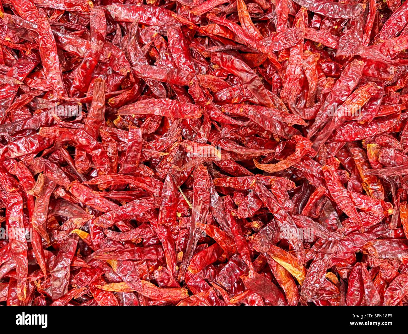 Pile de piments rouges séchés sur un marché mexicain – Texture de fond pour ingrédient alimentaire épicé Banque D'Images