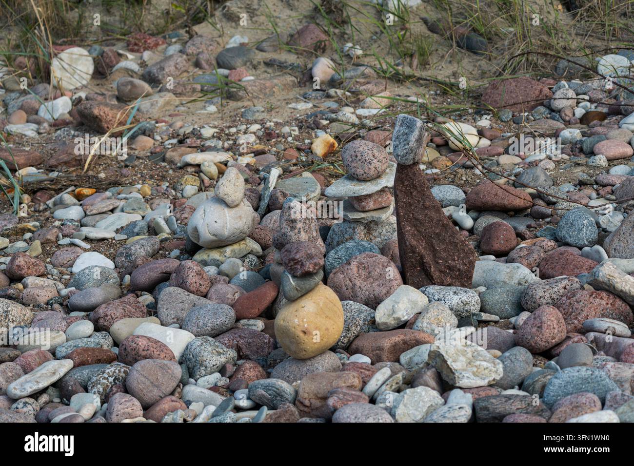 Petits cairns de pierre sur une plage de galets multicolores Banque D'Images