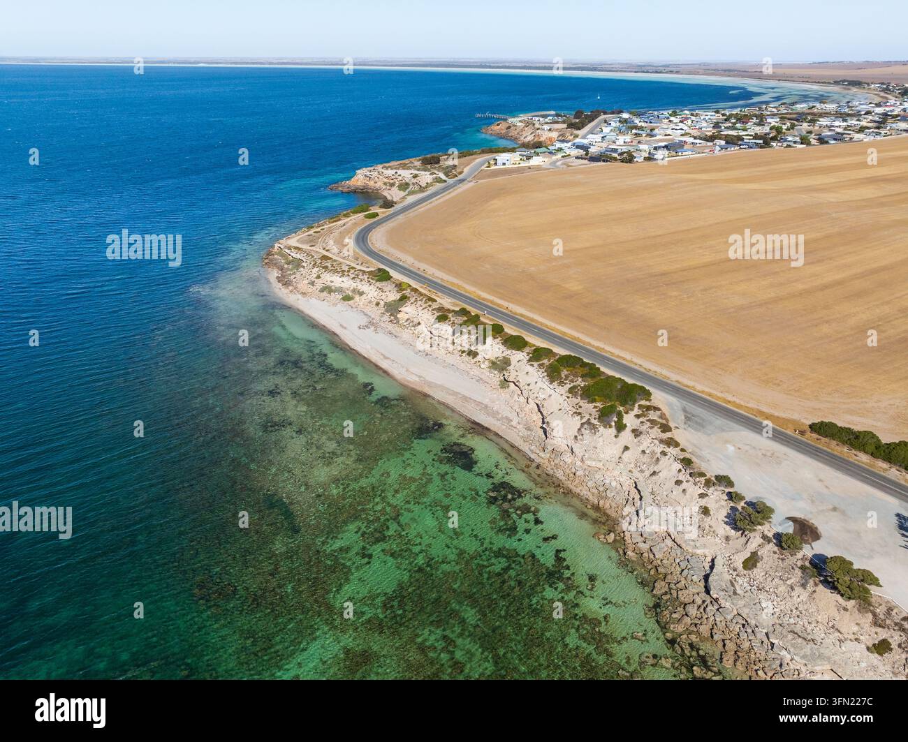 Vue aérienne d'une route côtière entre l'océan et des terres agricoles sèches à Point Turton sur la péninsule de Yorke en Australie du Sud. Banque D'Images