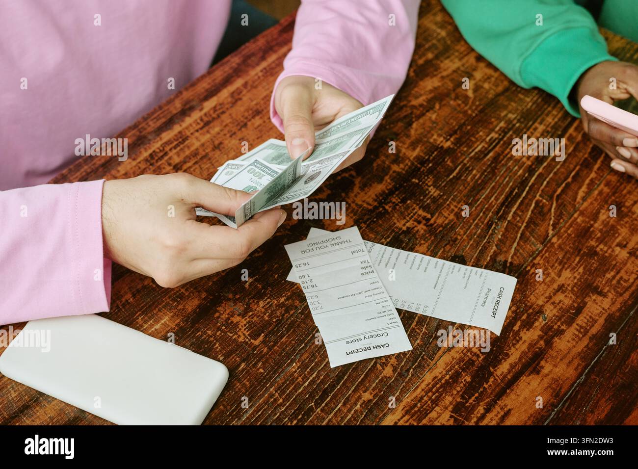 Amis multiethniques comptant de l'argent et vérifiant des reçus dans un café Banque D'Images