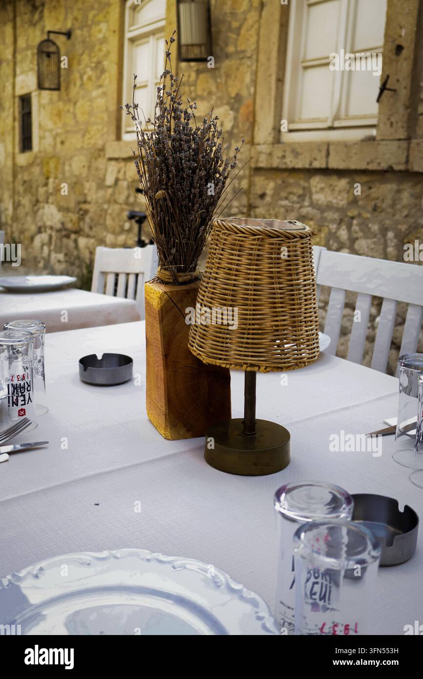 Table de restaurant extérieur avec lampe en osier et lavande Banque D'Images