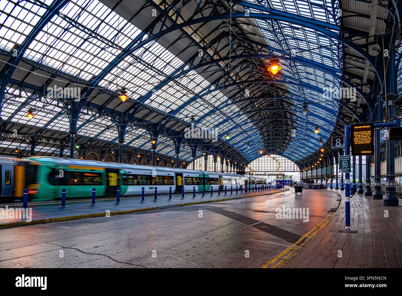 Un train du Sud quittant une gare de Brighton déserte Banque D'Images