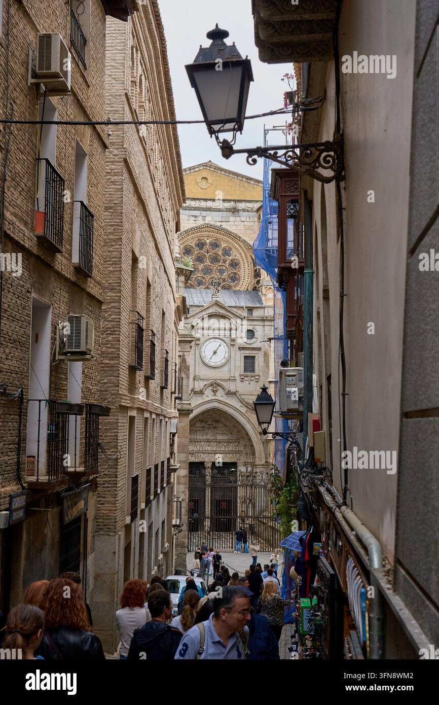Des foules marchant dans la Calle Chapinería en direction de la Puerta del Reloj, la porte de l'horloge et le rosace du côté nord de la cathédrale de Tolède, Espagne Banque D'Images