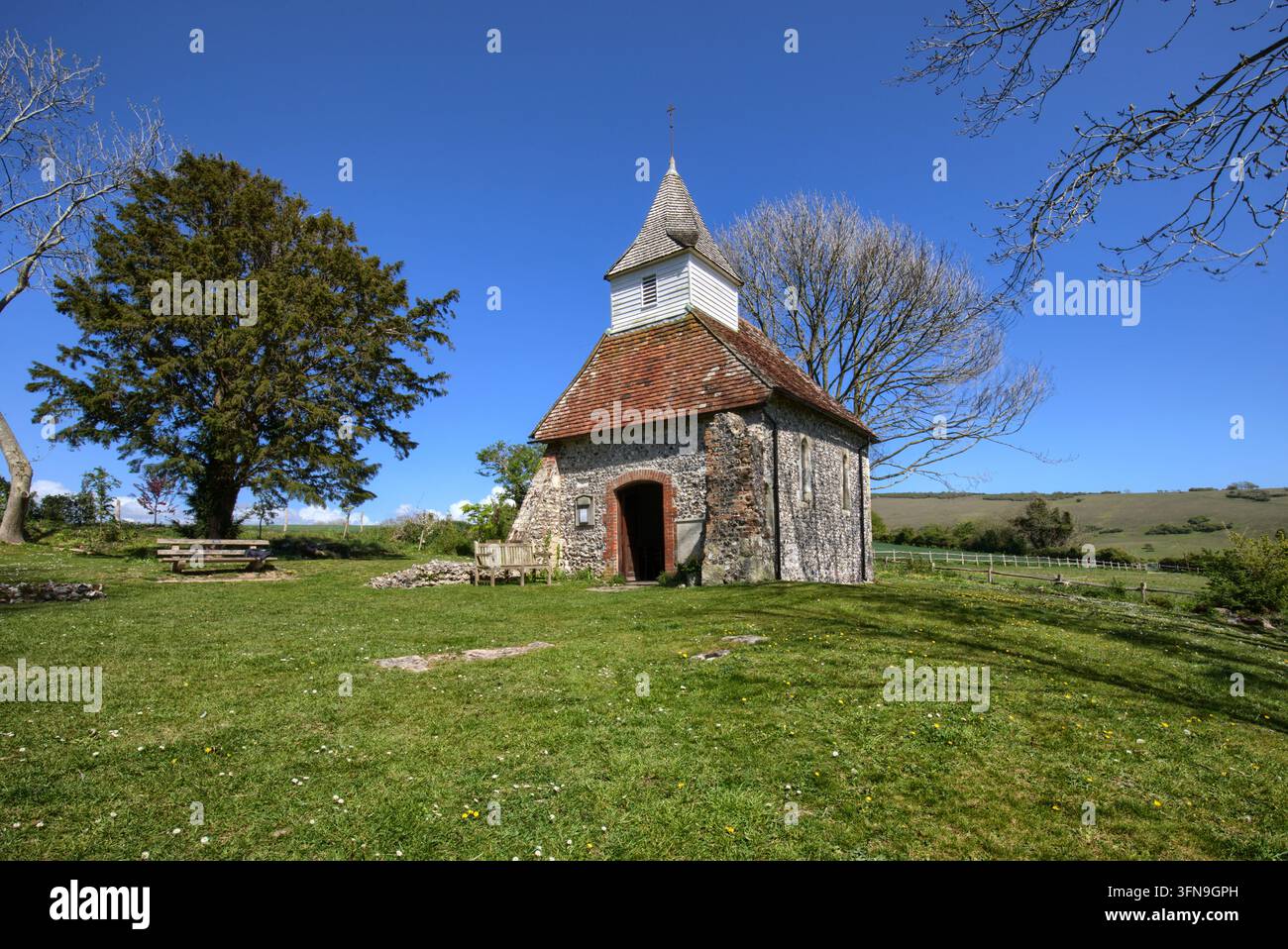 L'église historique de Lullington du XIIIe siècle, connue comme la plus petite église du Sussex, se dressant sous un ciel bleu clair dans les South Downs. Banque D'Images