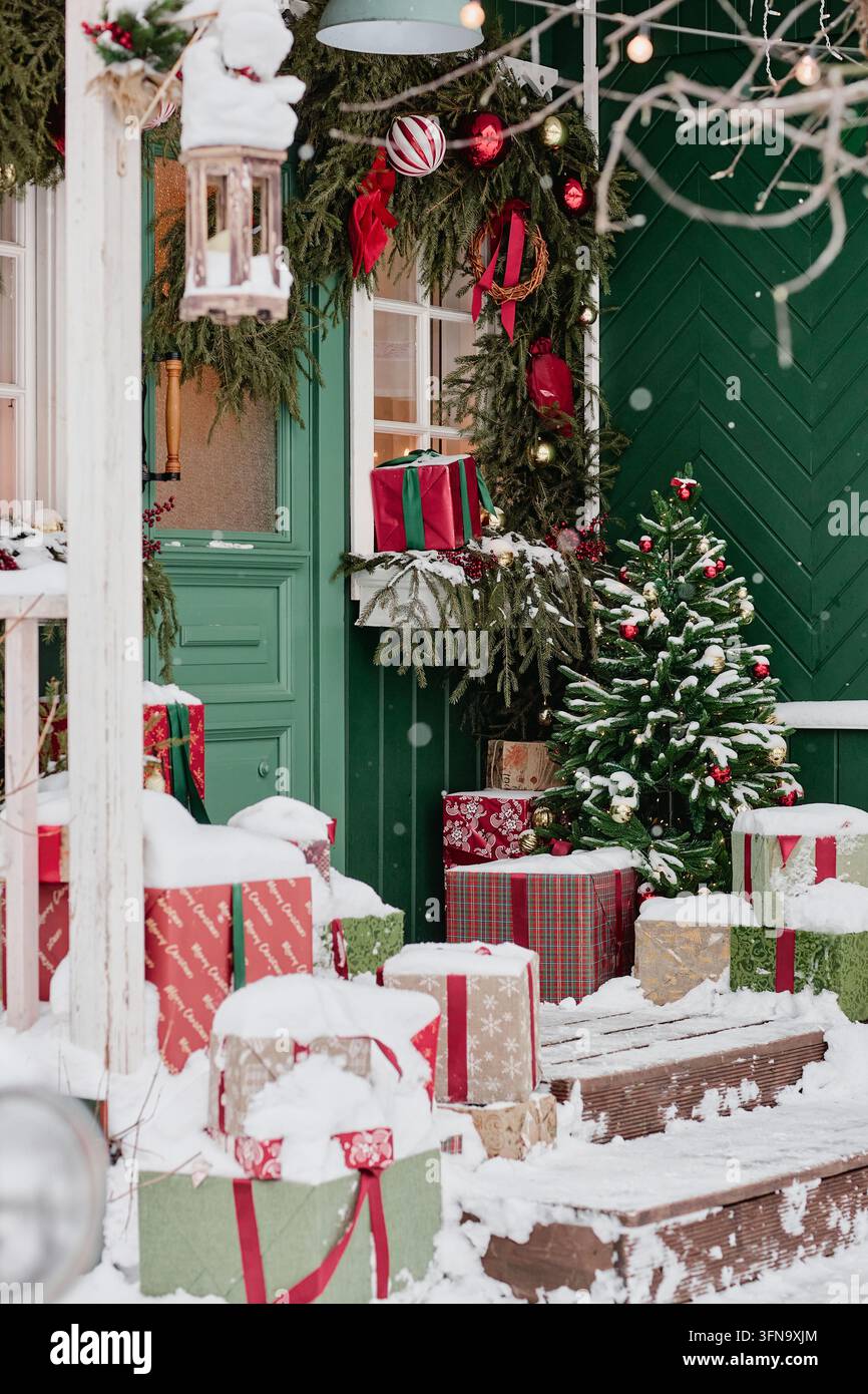 Boîtes cadeaux de Noël avec sapin décoré sur un porche enneigé Banque D'Images