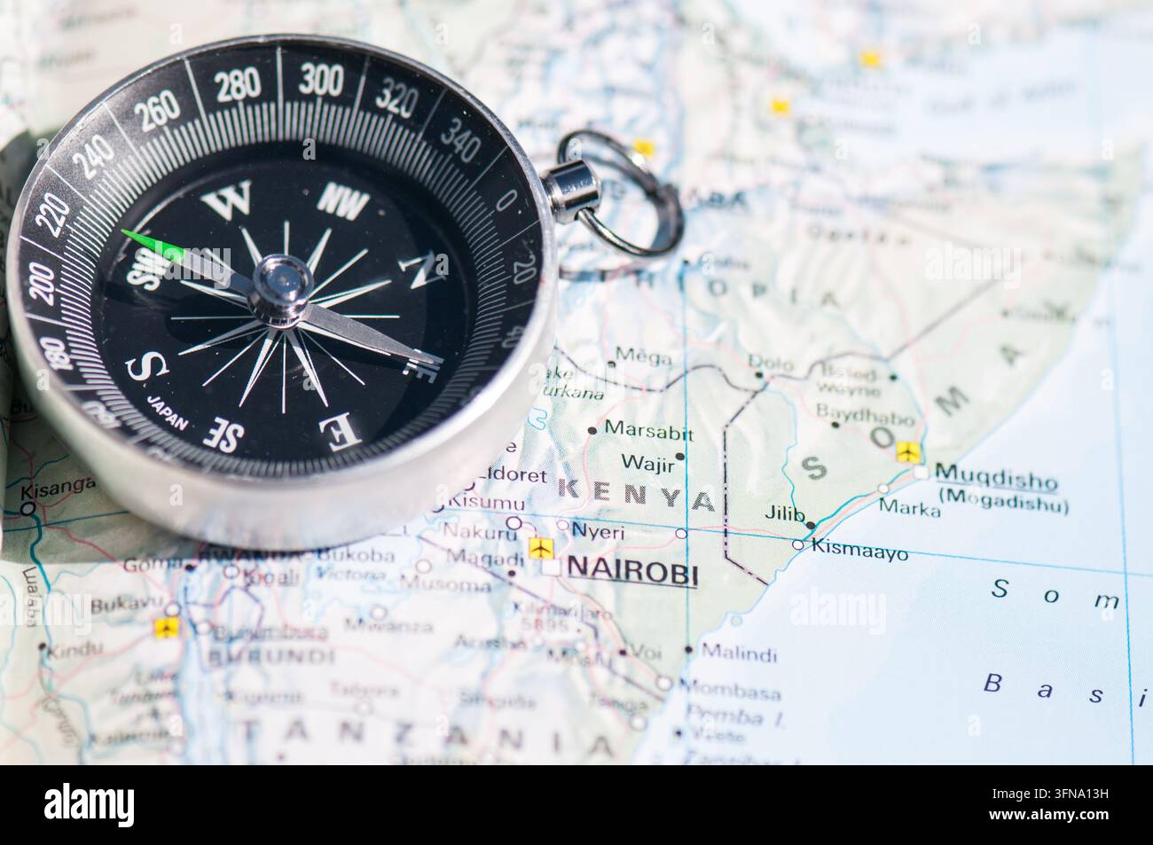 Vue d'une boussole magnétique reposant sur une carte détaillée de l'Afrique de l'Est mettant en évidence le Kenya. Banque D'Images