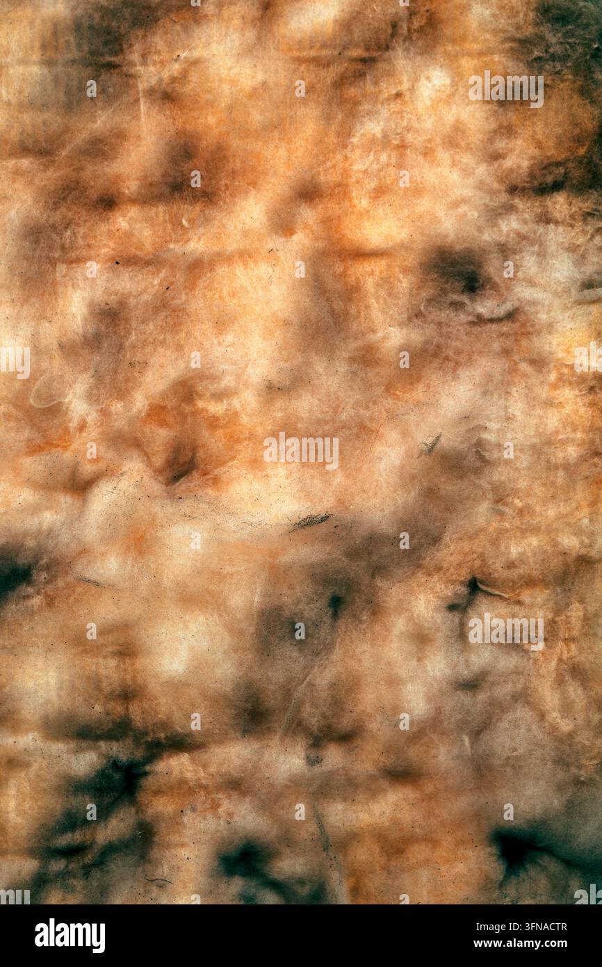 Photographie macro verticale d'une texture de pierre de marbre abstractionnée et patinée avec des tons ocre chauds et des marbrures minérales sombres comme fond de conception. Banque D'Images
