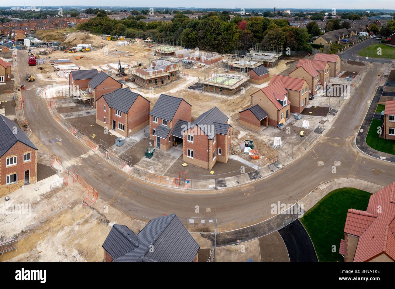Vue aérienne d'un chantier de construction de maisons écologiques neuves et abordables pour combler le manque de logements sociaux au Royaume-Uni sur un terrain vert Banque D'Images