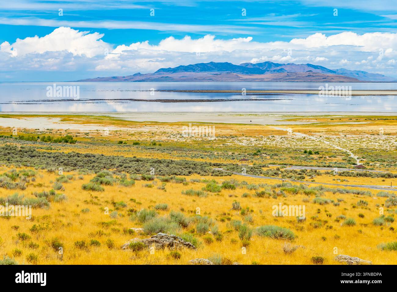 Les eaux calmes du Grand Lac Salé reflètent les chaînes de montagnes lointaines le long de la rive du parc d'État d'Antelope Island dans l'Utah Banque D'Images