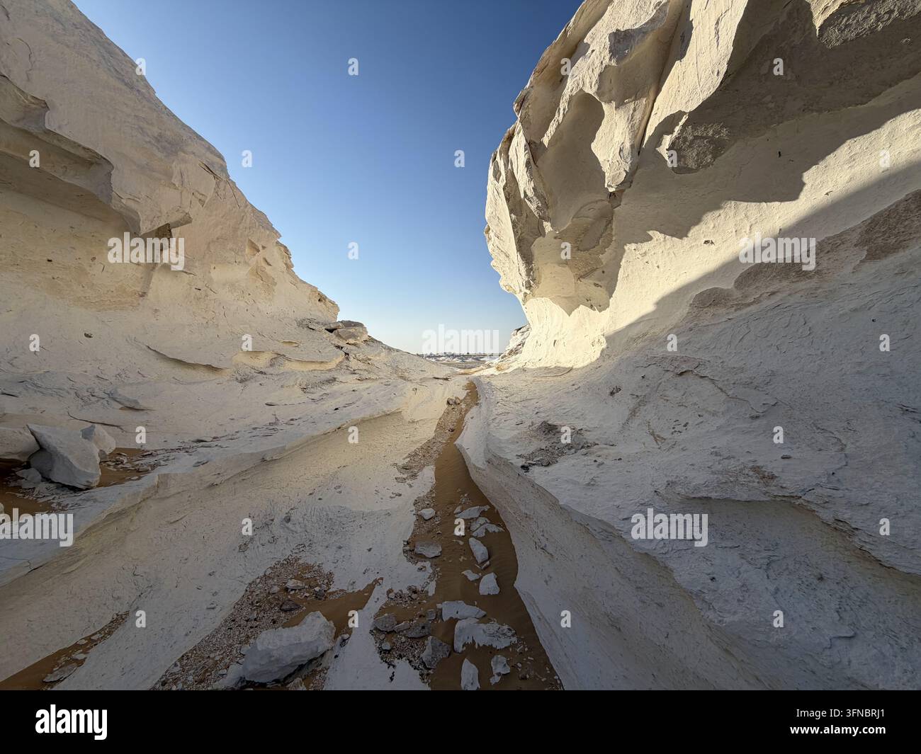 Corridor ensoleillé entre des falaises incurvées du Désert Blanc, photographié dans le parc national du Désert Blanc dans le désert de l'Ouest égyptien. - Image de stock capturée avec un smartphone