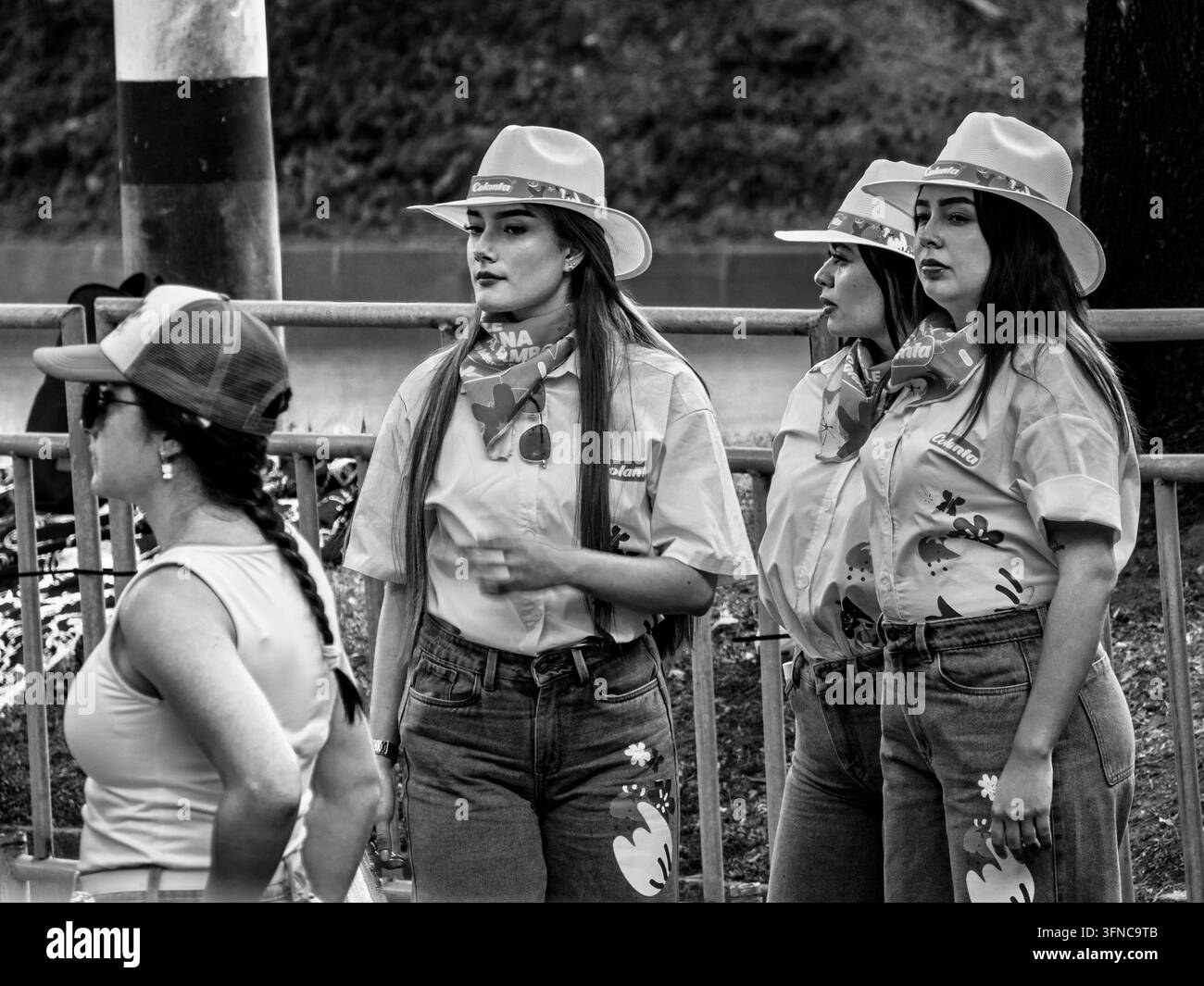 Medellin, Antioquia, Colombie, jeunes femmes portant des chemises blanches assorties avec des imprimés floraux, des jeans en denim et des chapeaux de soleil en paille de marque. Noir et blanc, Banque D'Images