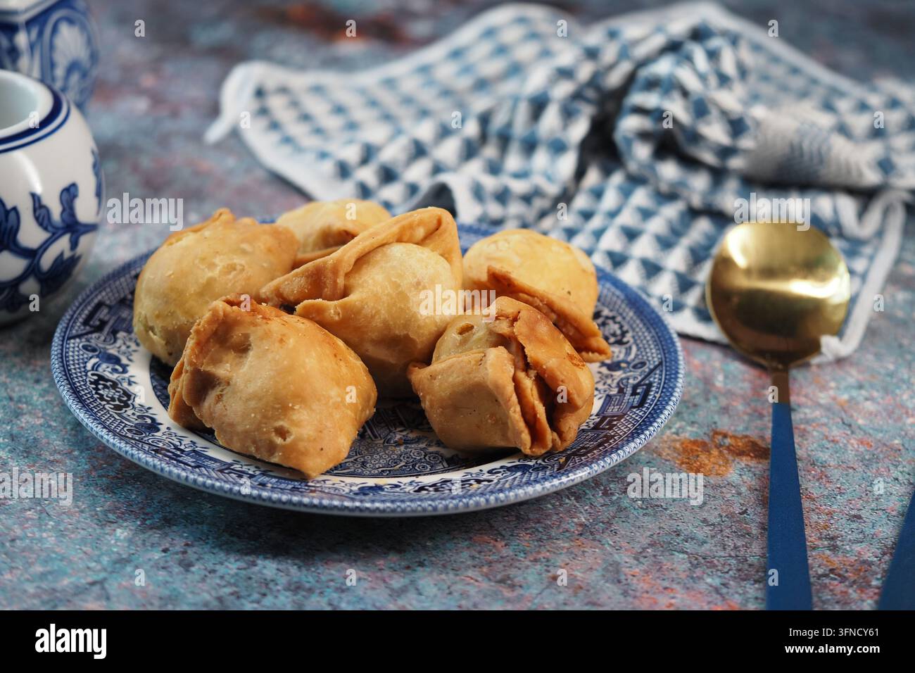une assiette de pâtisseries triangulaires frites dorées qui semblent être des singara Banque D'Images