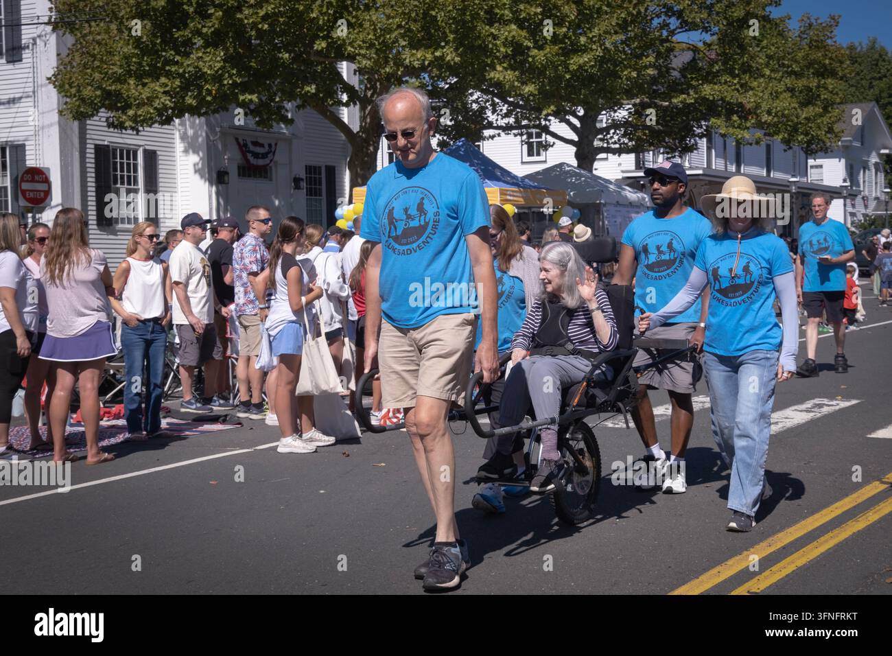 Les membres de Luke 5 Adventures Adaptive hiking aident une personne handicapée à défiler dans la parade du Labor Day de Newtown en 2026. Le vélo rickshaw à une roue s'appelle Rosie Banque D'Images