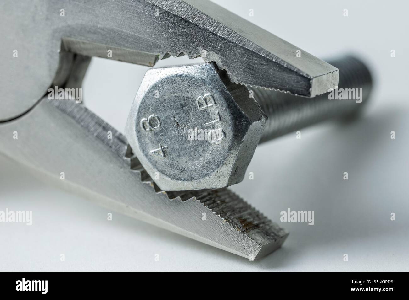 Pince saisissant un boulon à tête hexagonale, représentant la réparation, la construction et l'ingénierie Banque D'Images