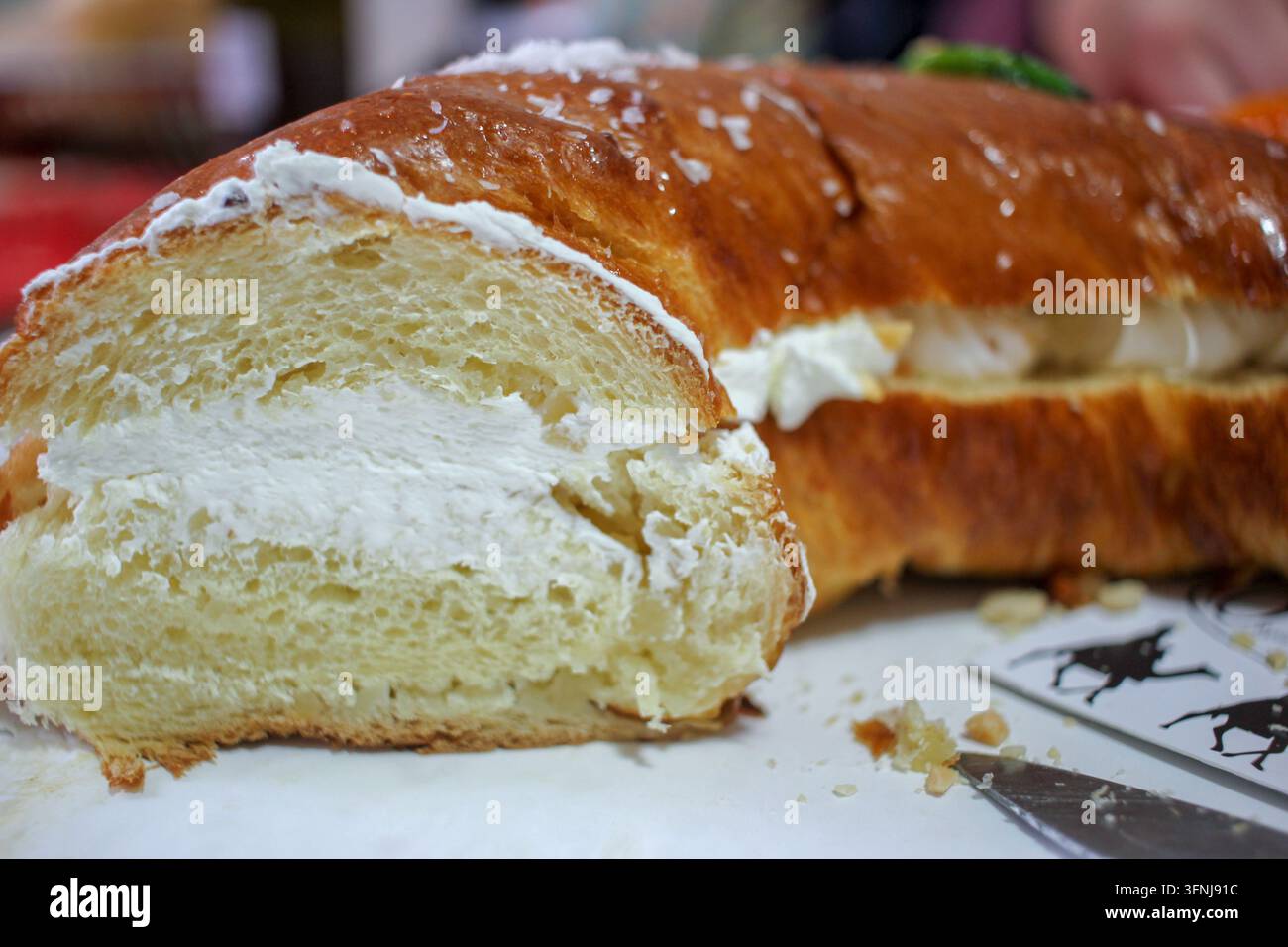Vue macro détaillée de la mie douce et de la garniture riche en crème fouettée d'un Roscon de Reyes, gâteau de Noël espagnol fraîchement coupé. Banque D'Images