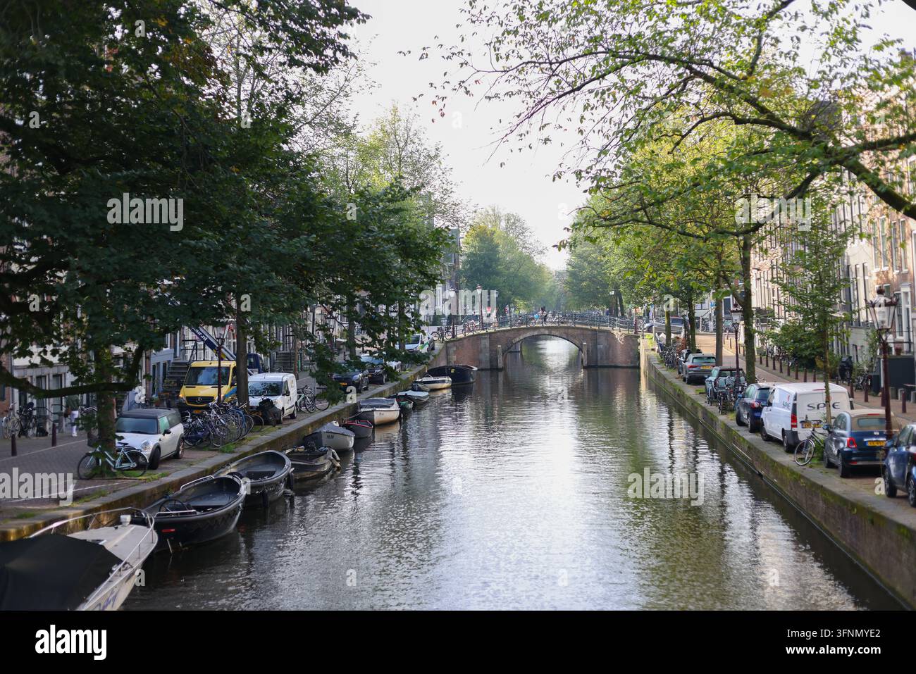Amsterdam, Pays-Bas – 2 octobre 2026 : Canal pittoresque avec des bateaux amarrés, des vélos et un petit pont dans le centre historique de la ville. Banque D'Images