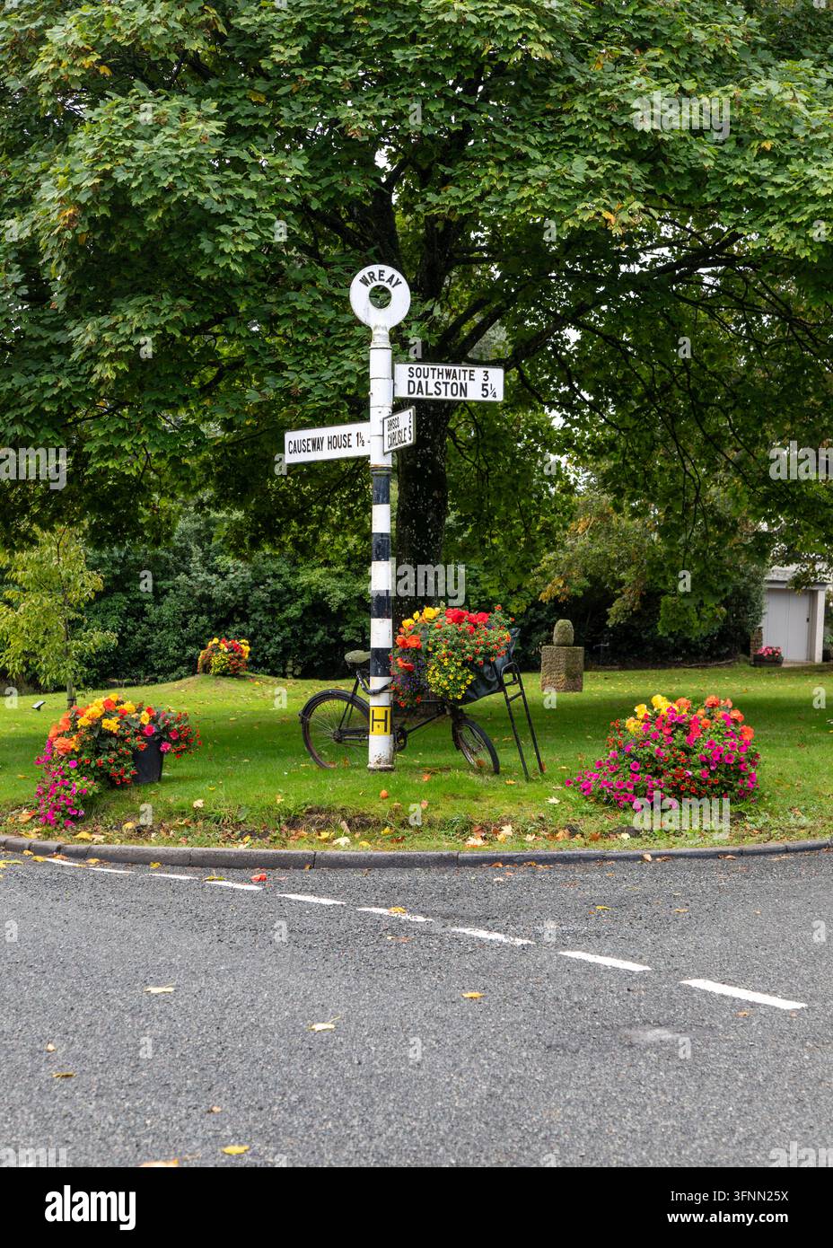 Ancien panneau sur l'herbe dans le pittoresque village de Wreay, en Cumbria, Angleterre Banque D'Images