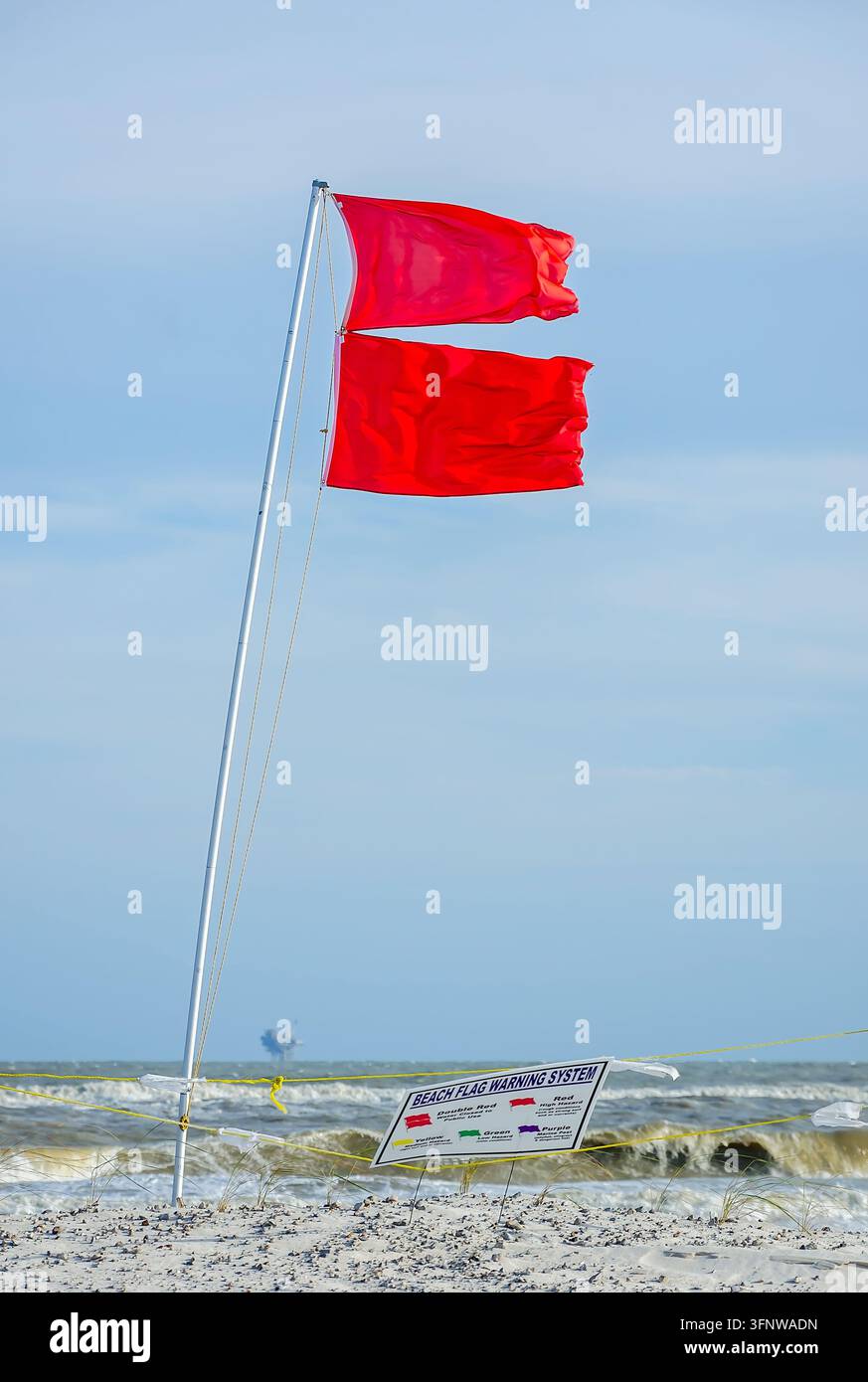 Des drapeaux rouges doubles signalent que les eaux sont fermées à l'usage public sur la plage de Dauphin Island le 18 juin 2024 à Dauphin Island, Alabama. Banque D'Images