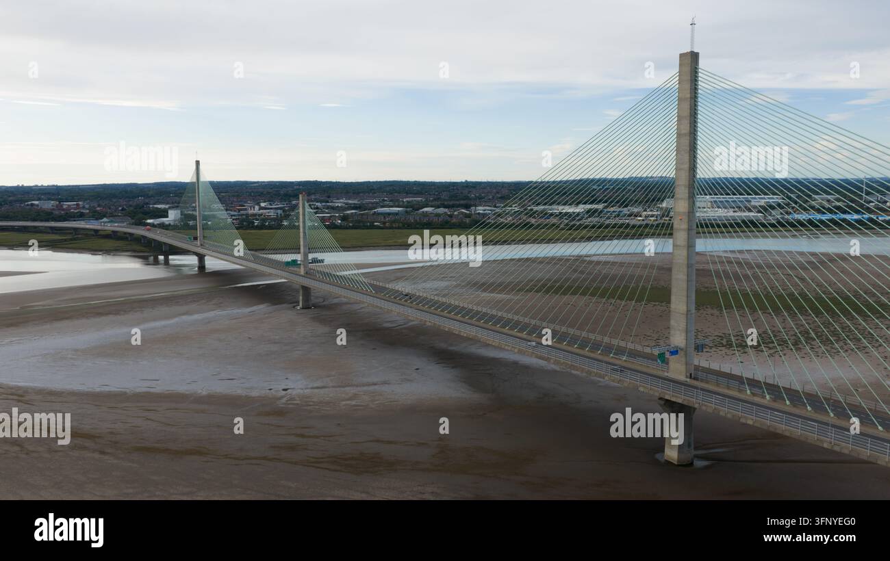 Vue aérienne du pont Mersey Gateway enjambant la rivière Mersey à marée basse avec des tours à câbles et le paysage environnant à Runcorn, en Angleterre Banque D'Images