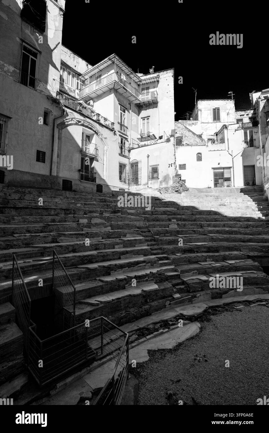 Vue des étals du Théâtre Romain d'Anticaglia (Théâtre Antique de Neapolis) avec les maisons environnantes dans le centre historique de Naples, en Italie. Banque D'Images
