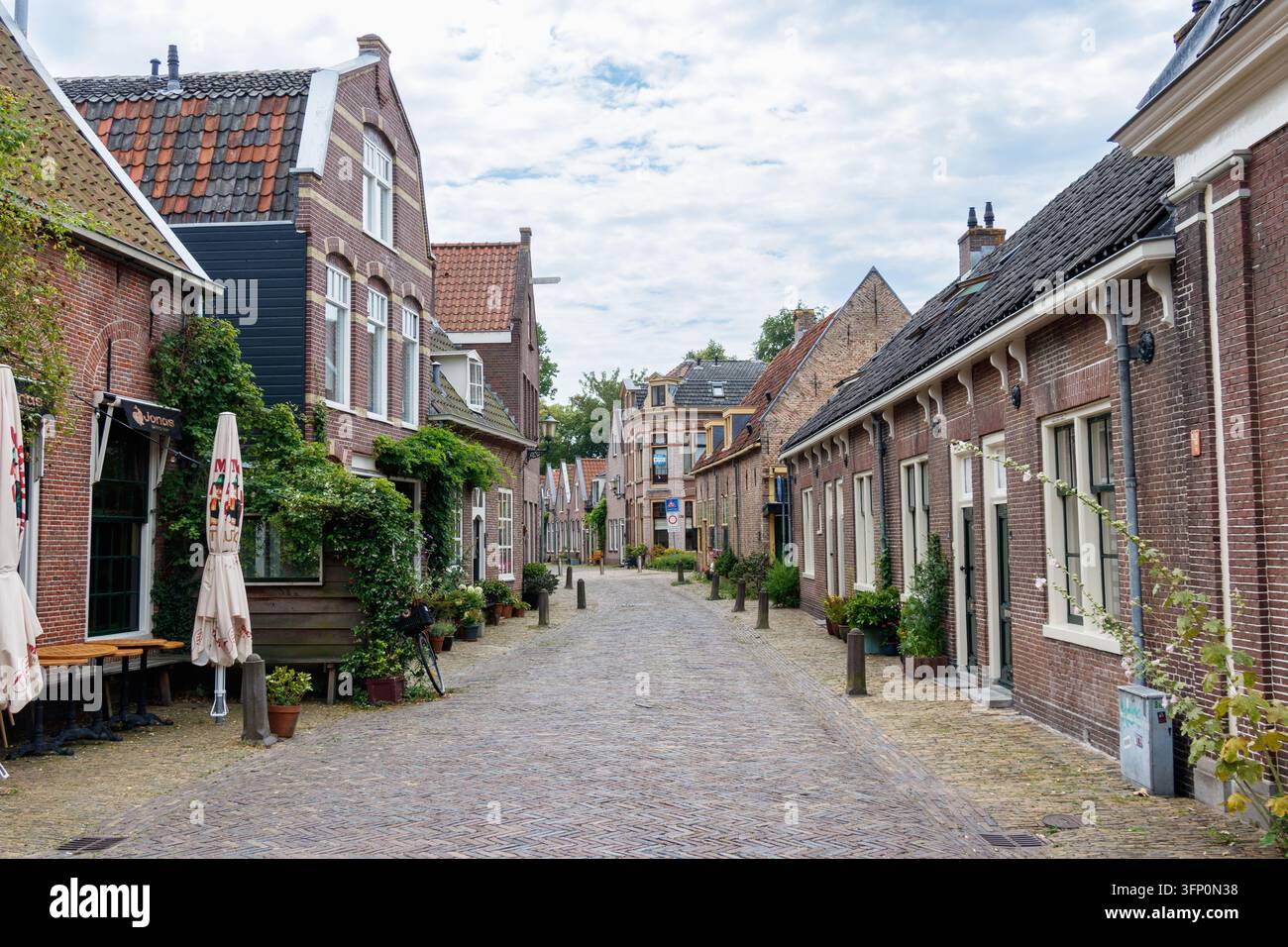 Rue pavée avec des maisons en briques à Alkmaar, Pays-Bas Banque D'Images