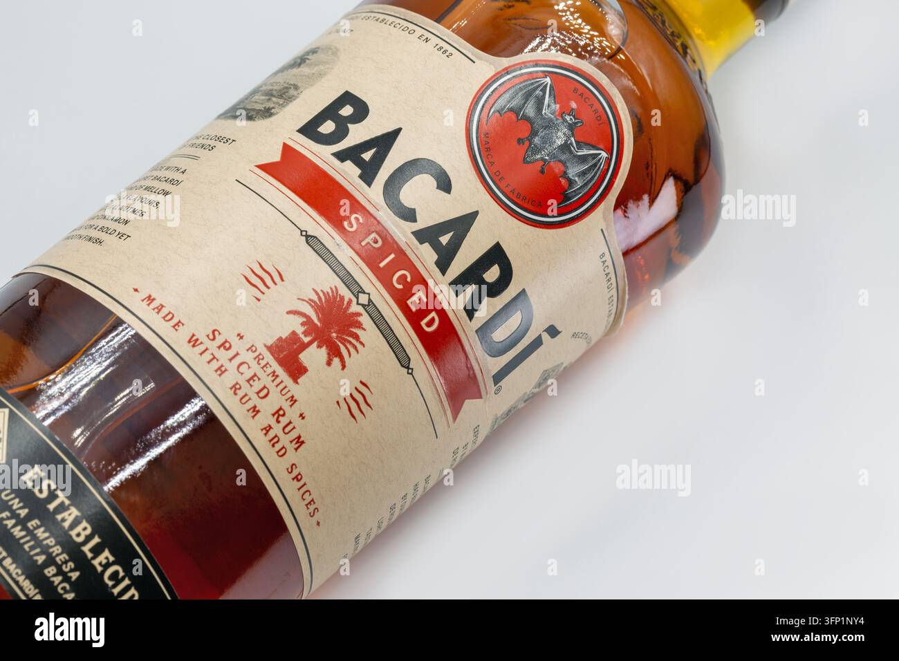 Kyiv, Ukraine - 26 juillet 2025 : bouteille de rhum premium Bacardi Spiced avec esprit ambré, logo distinctif de chauve-souris et étiquette de marque, gros plan sur un stu blanc propre Banque D'Images