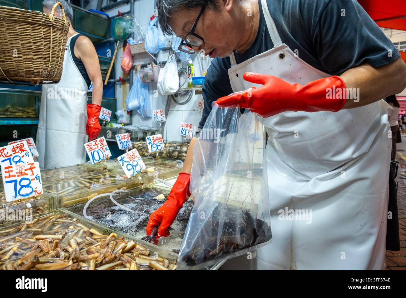 Un vendeur préparant des fruits de mer pour un client au marché humide de Wan Chai sur l'île de Hong Kong. Banque D'Images