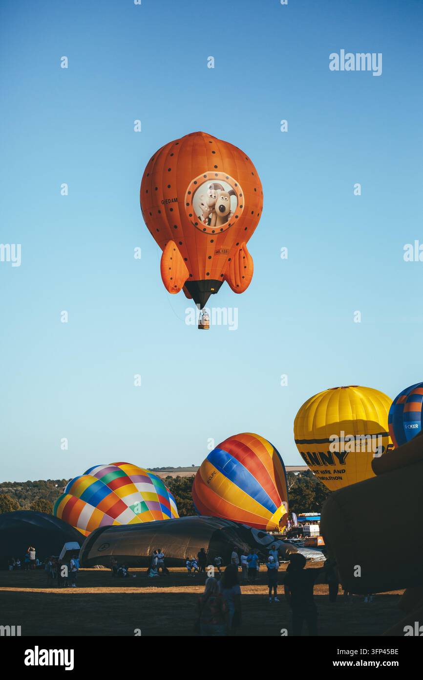 Bristol Balloon Fiesta, 7 août 2026, Royaume-Uni - Ballon à air chaud en forme de fusée Wallace et Gromit survolant le champ de lancement Banque D'Images