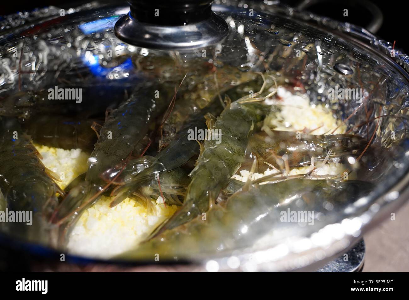 Crevettes ou crevettes crues fraîches placées sur du sel grossier dans une casserole avant la cuisson Banque D'Images