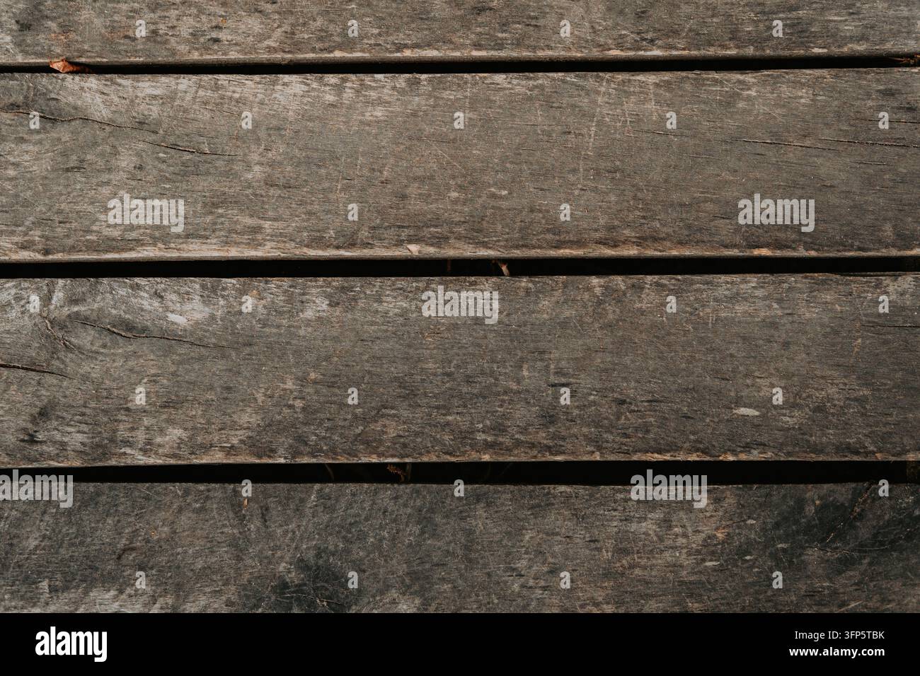 Photographie en vue plate de planches de bois sombres, patinées et vieillies présentant des textures rustiques, des fissures et une veine naturelle. Idéal pour la conception d'arrière-plan Banque D'Images