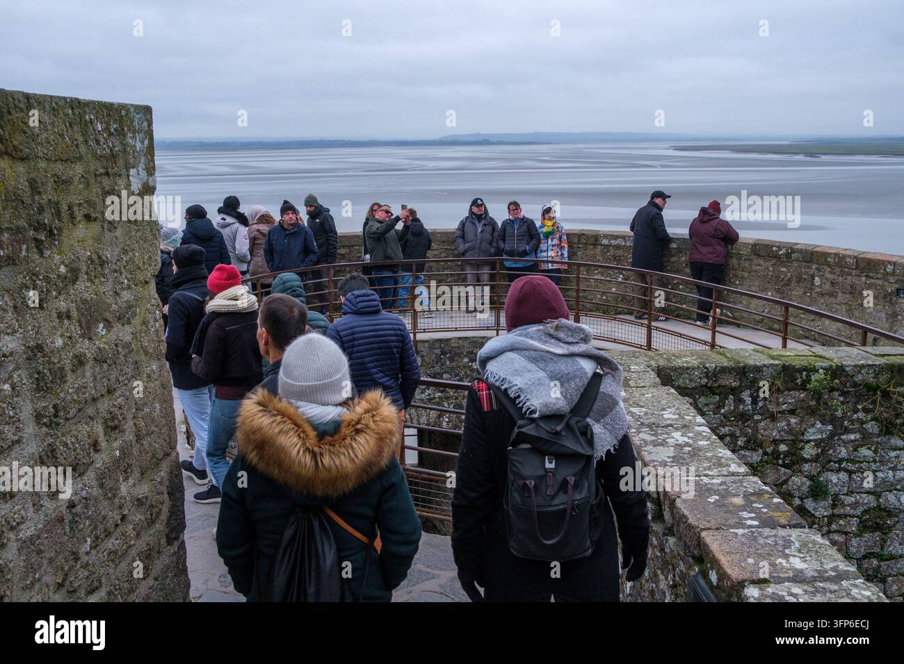 Un flux dense de visiteurs emprunte le chemin de pierre à travers les jardins nord de l'abbaye du Mont-Saint-Michel au-dessus de la baie à Le Mont-Saint-Michel, Manche, No Banque D'Images