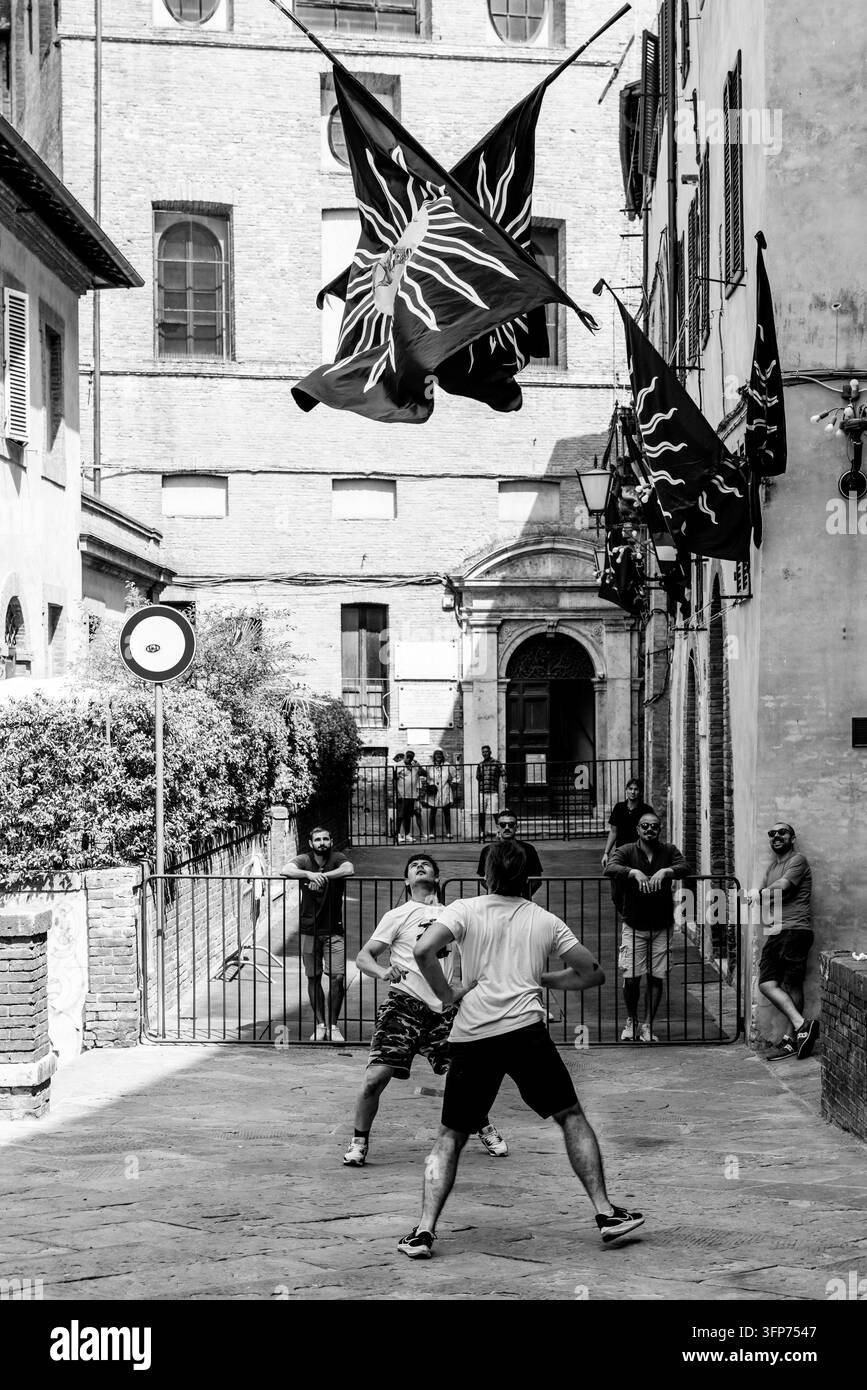 Les danseurs et lanceurs de drapeaux de Torre Contrada s'entraînent dans leur quartier avant de participer à la procession historique, Il Palio di Siena, Sienne, Italie. Banque D'Images