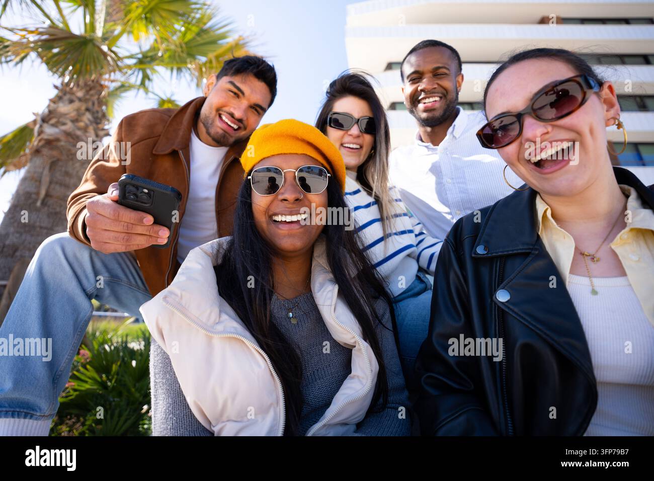 Groupe divers d'amis souriant en plein air dans un cadre moderne Banque D'Images