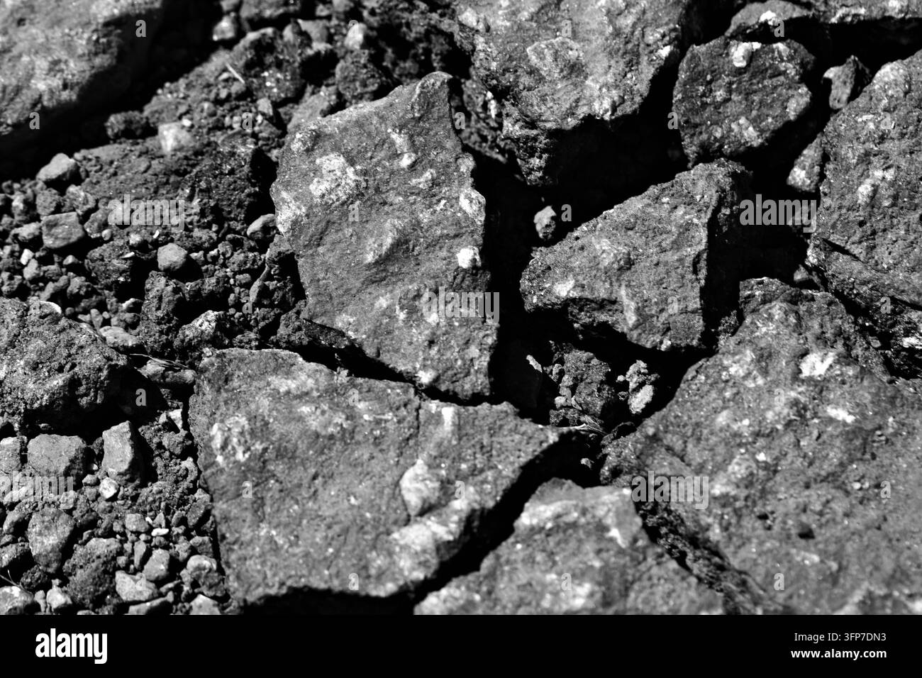 Close-up de roche concassée rugueuse, gravier, sol et agrégat grossier créant une texture robuste de matériaux naturels et de construction. Banque D'Images