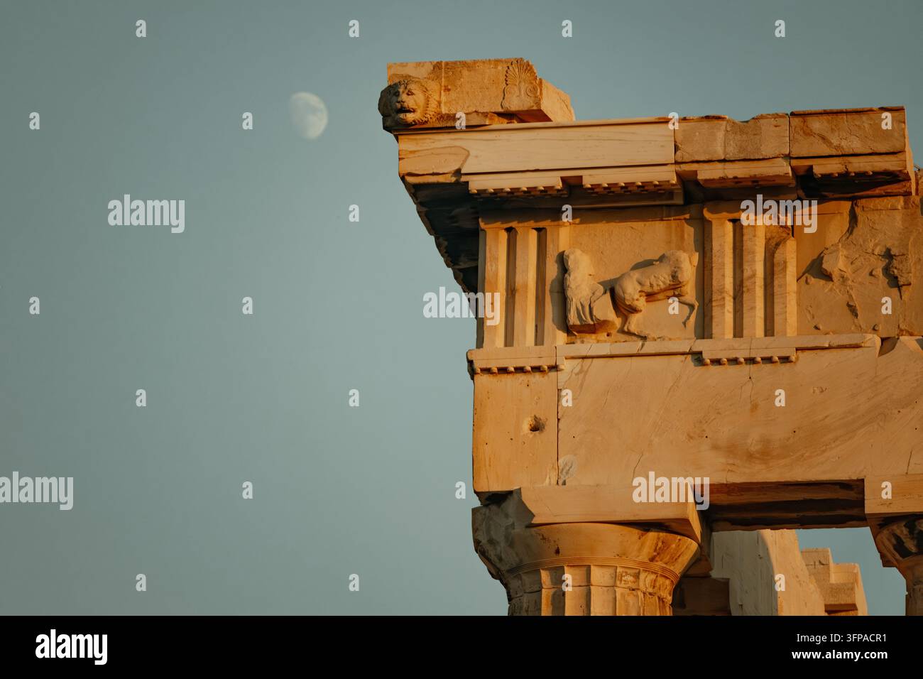 Vue de l'architecture ancienne en marbre de l'Acropole présentant un gargouille en tête de lion sculptée et un frise classique sous un ciel dégagé avec un M visible Banque D'Images