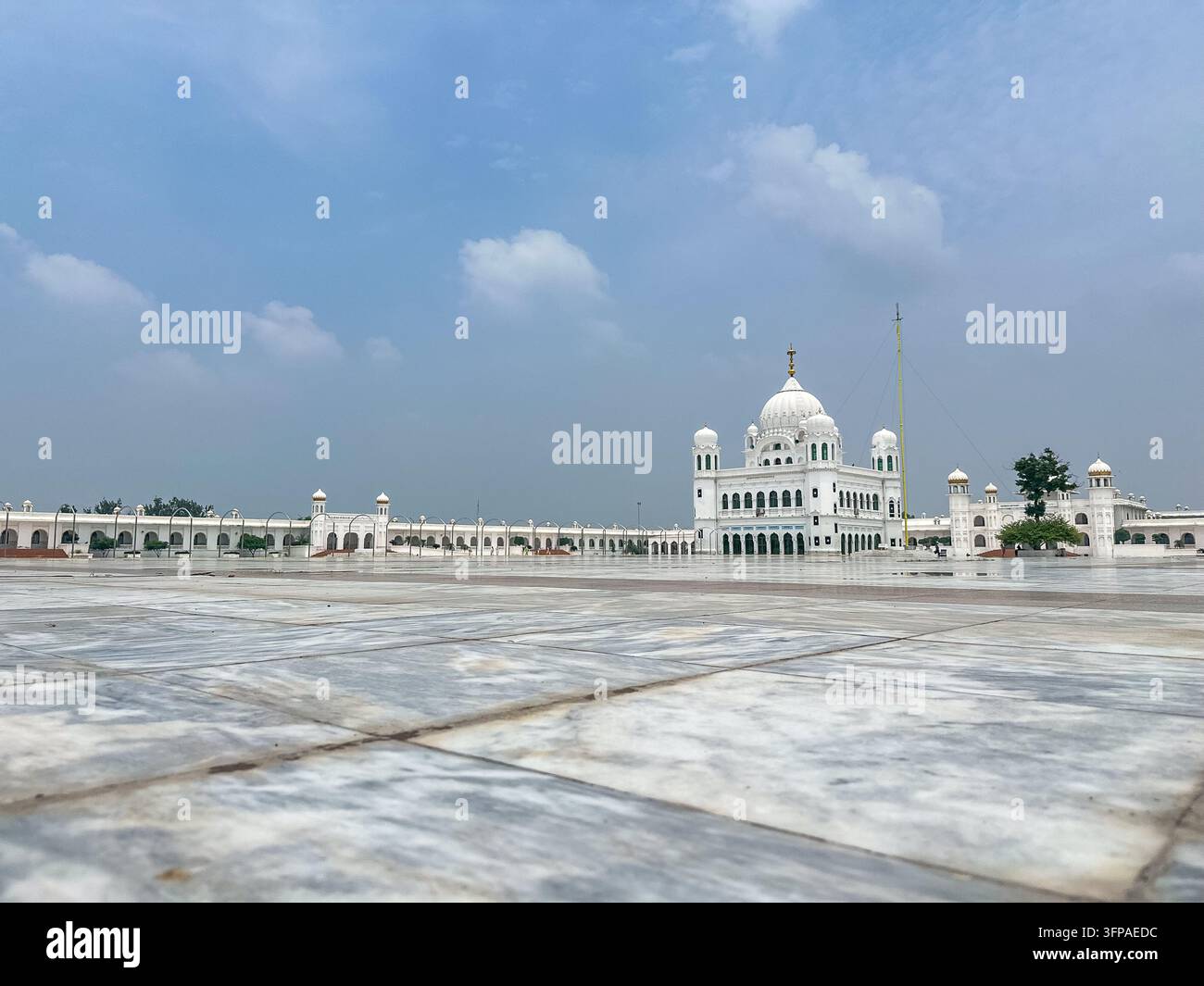 Vue de l'architecture en marbre blanc du Gurdwara Janam Asthan avec ses dômes proéminents et sa cour étendue à Nankana Sahib, Punjab, Pakistan. Banque D'Images