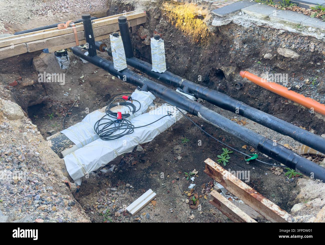 Rénovation et remplacement d'une conduite de gaz dans une rue urbaine. Le chantier de construction montre une tranchée creusée avec des travaux de services souterrains comme agin Banque D'Images