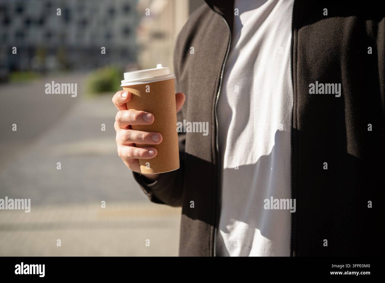 Homme tenant un café à emporter en plein air Banque D'Images