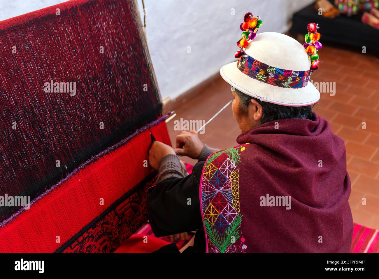 Femme indigène en vêtements traditionnels tissant un tissu Jalq'a à Sucre, Bolivie. Banque D'Images