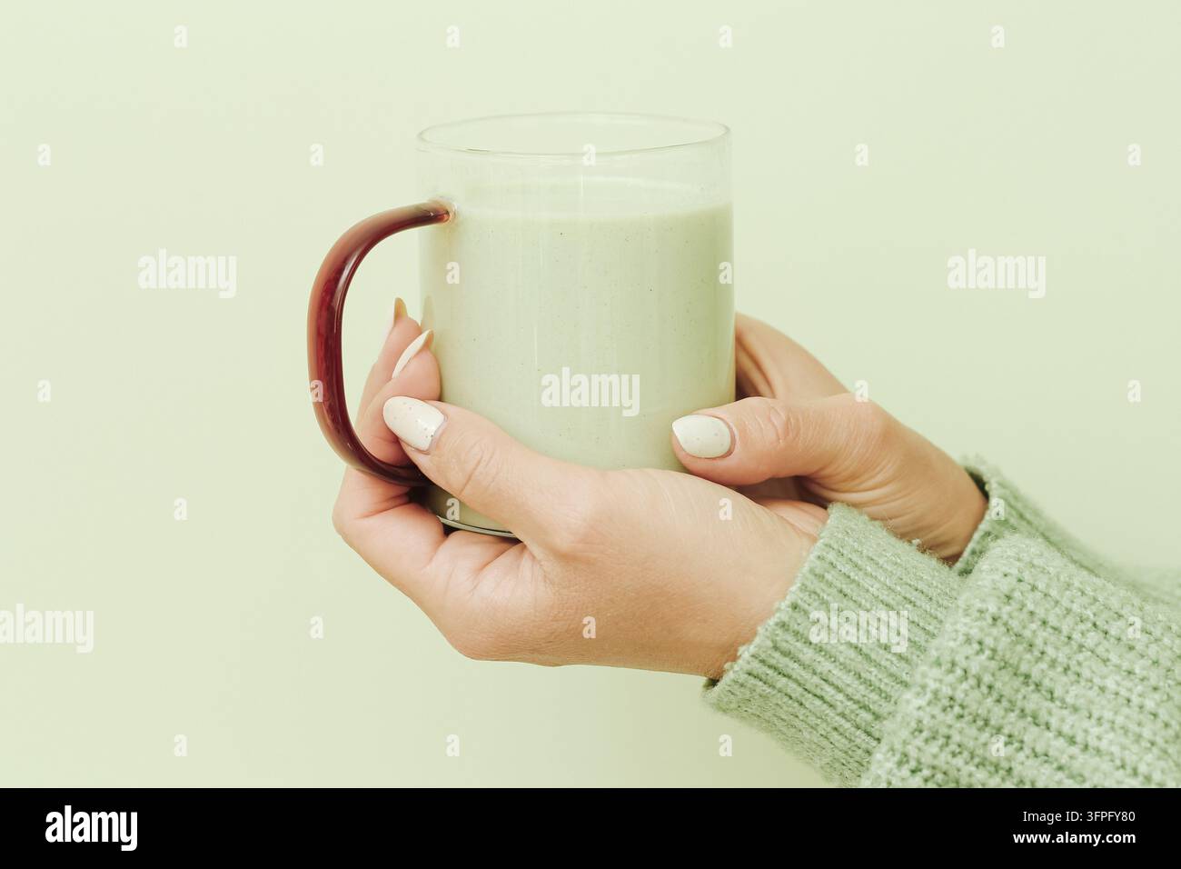 Femme tenant une tasse en verre de thé vert matcha. Arrière-plan de boisson saine pour le thé japonais, les antioxydants, le bien-être, la nutrition et le style de vie quotidien. Banque D'Images