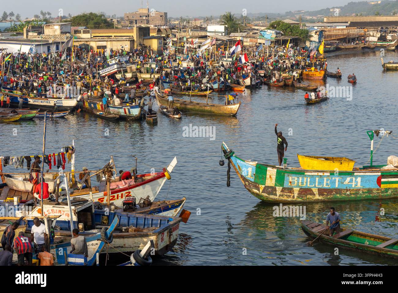 Port de pêche bondé rempli de bateaux en bois et de pêcheurs, Région centrale, Elmina, Ghana Banque D'Images