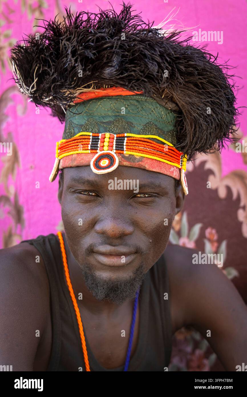 Portrait d'un homme de la tribu Turkana avec un couvre-chef en plume d'autruche noire, un bandeau perlé et des colliers, comté de Marsabit, Loiyangalani, Kenya Banque D'Images