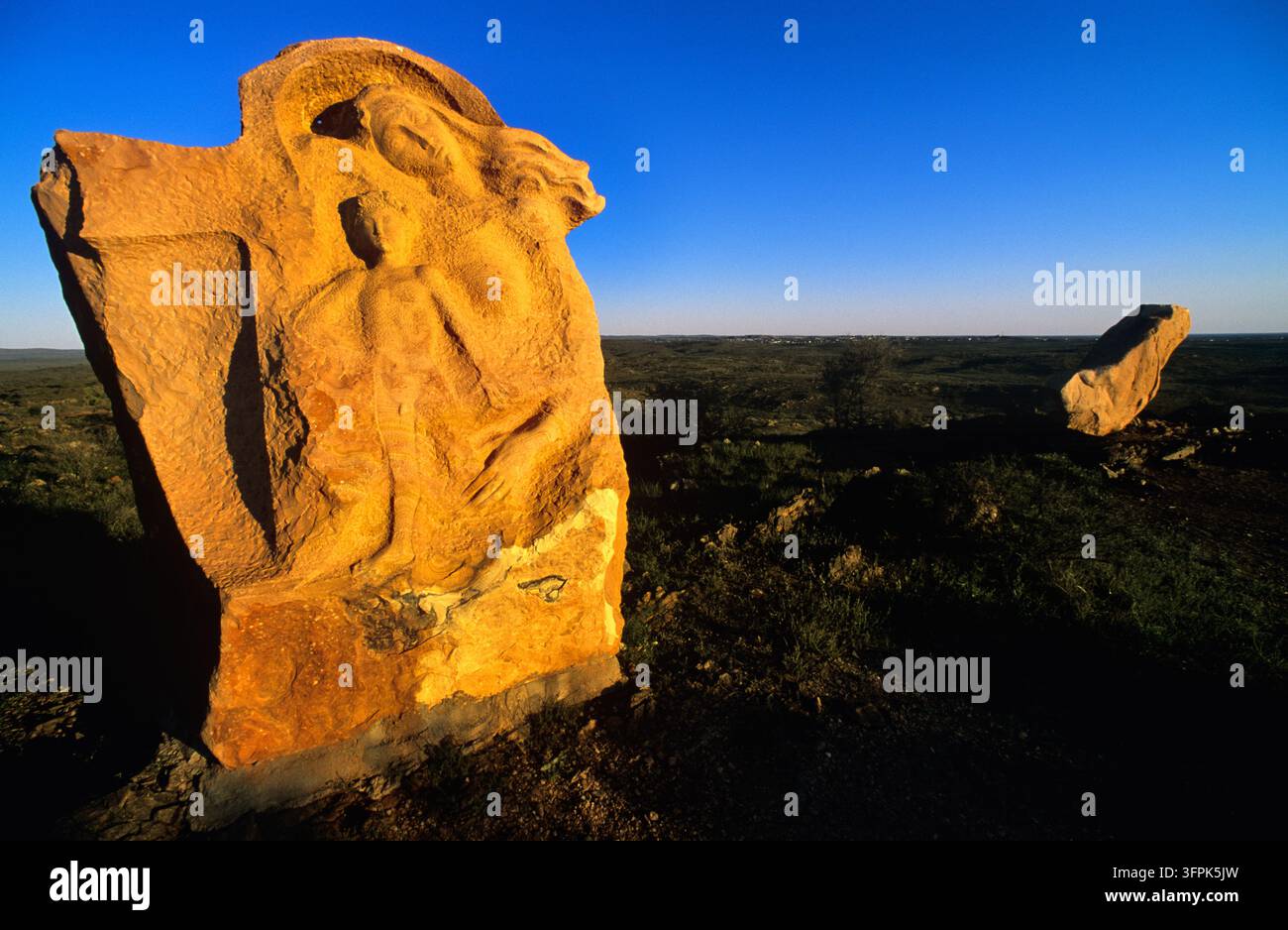 Sculpture en grès sculptée avec des figures humaines sur une colline au-dessus de l'outback près de Broken Hill, Nouvelle-Galles du Sud, à la lumière de l'heure dorée Banque D'Images