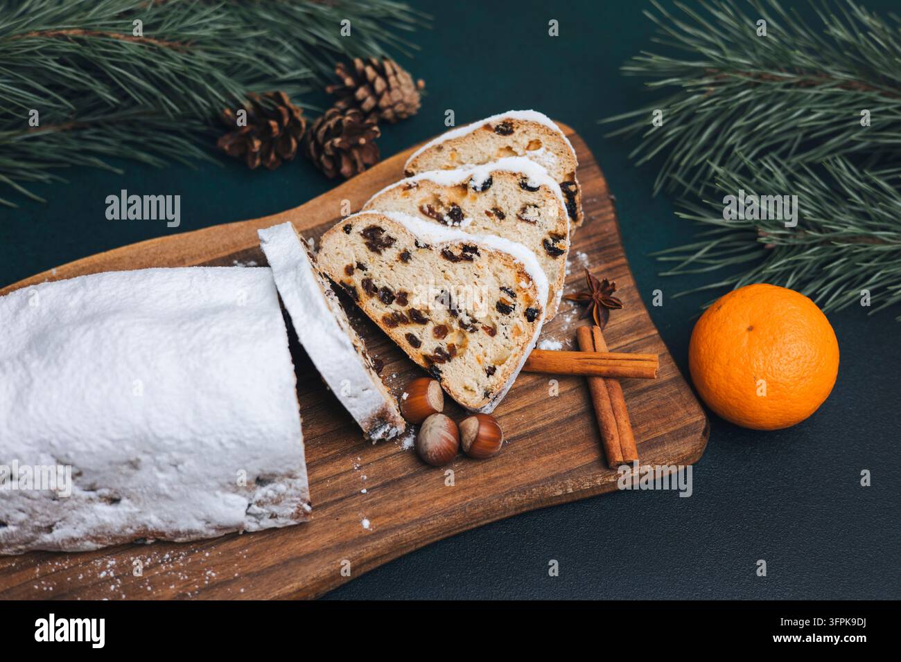 Tranches de Stollen traditionnel de Noël avec cannelle, orange et branches de pin Banque D'Images