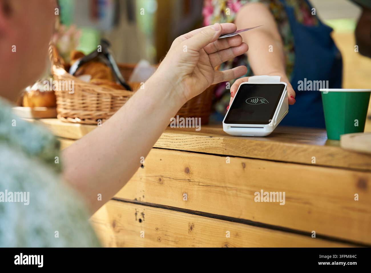 Gros plan d'une personne effectuant un paiement sans contact pour un café à emporter Banque D'Images