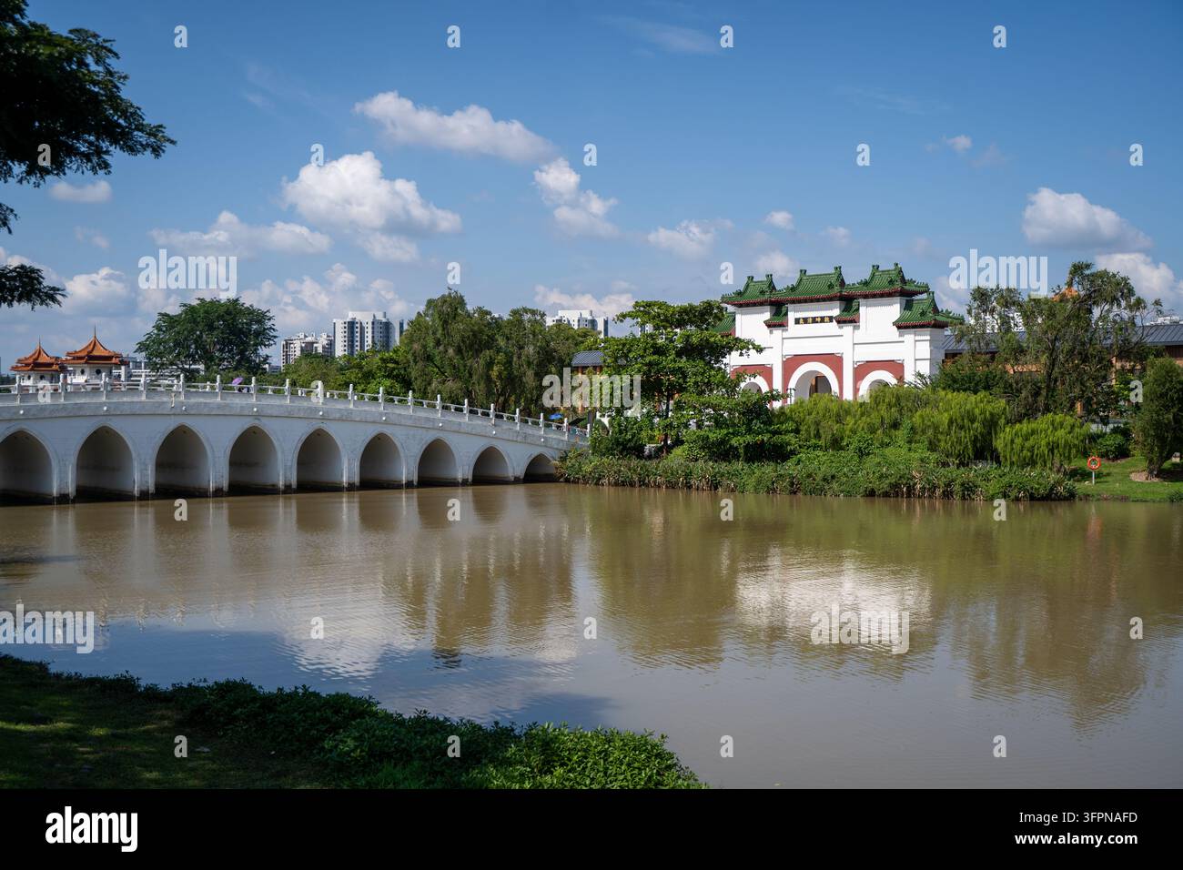 Le pont en arche blanc et le pavillon reflétés dans le lac Jurong au Jardin chinois de Singapour Banque D'Images